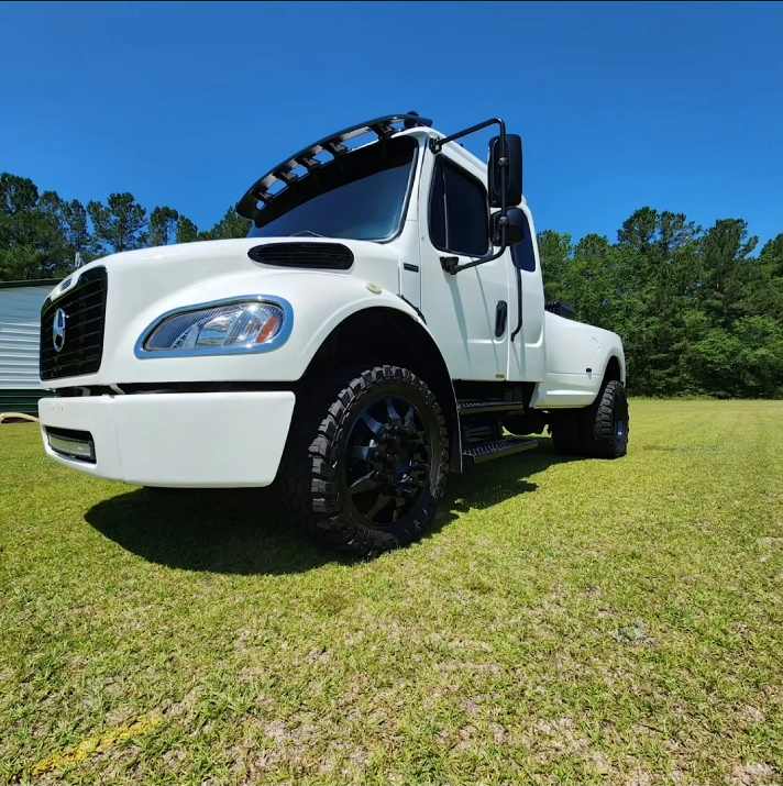 A White Freightliner Medium-duty Truck Parked on a Grassy Field — Valentine Detailing LLC in Walterboro, SC