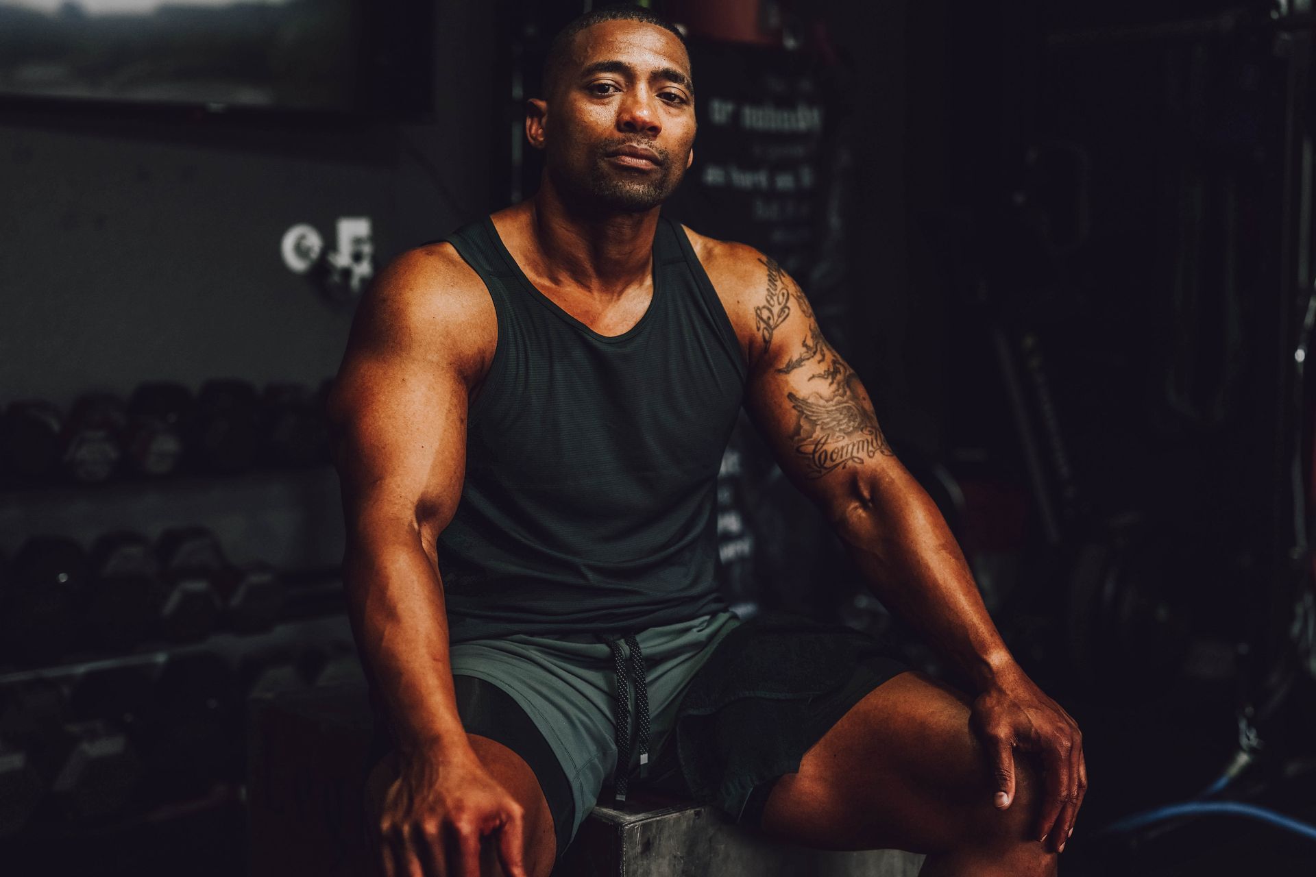 A man is sitting on a bench in a gym.