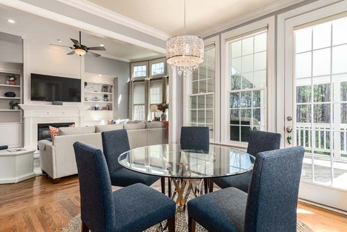 A dining room with a glass table and blue chairs.