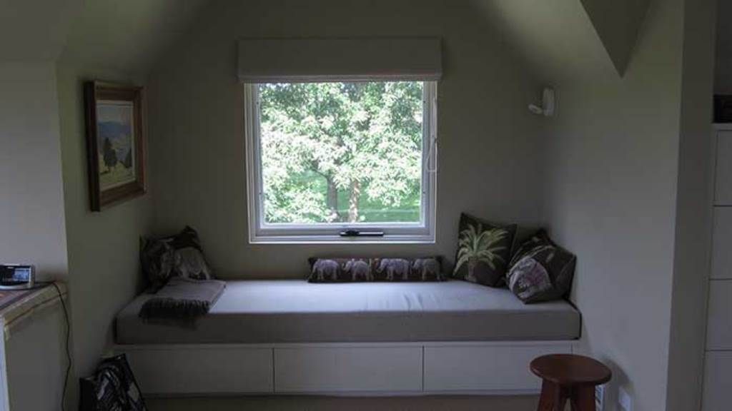 There is a couch in the corner of the room next to a window — GMT Builders Pty Ltd in Milton Park, NSW