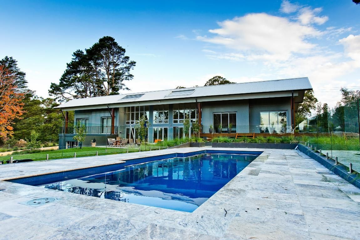 A Large House with A Swimming Pool in Front of It — GMT Builders Pty Ltd in Sunninghill, NSW