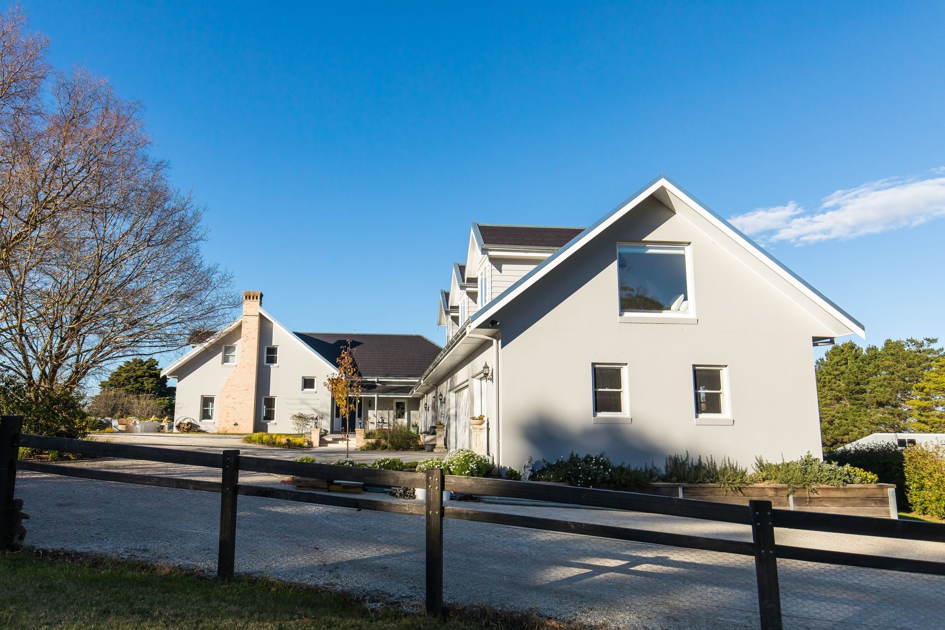 A Large House with A Concrete Driveway Leading to It — GMT Builders Pty Ltd in Berrima, NSW