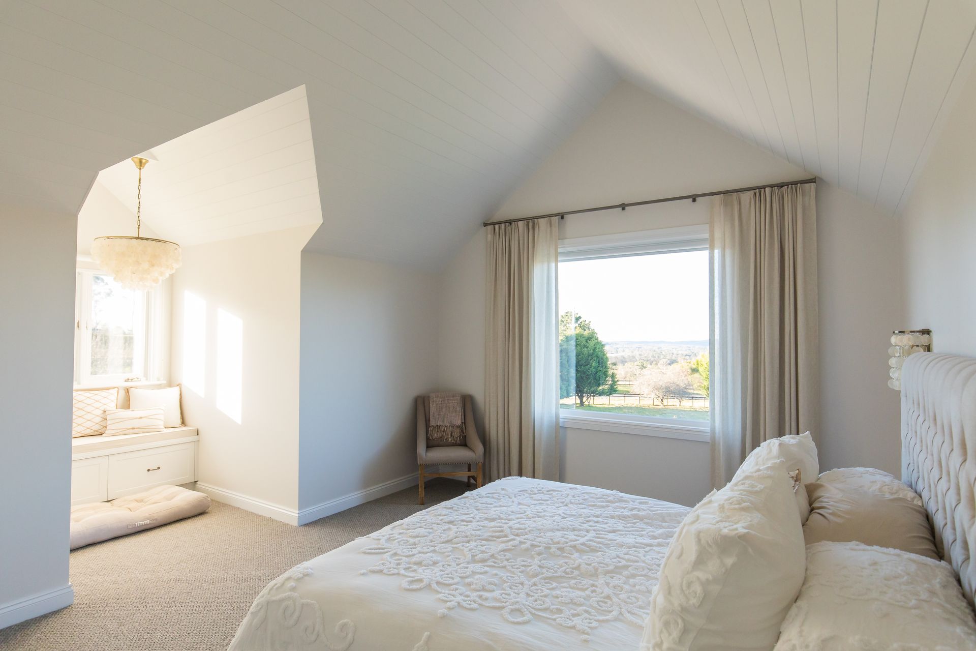 A bedroom with a bed , chair and window — GMT Builders Pty Ltd in Badine, NSW