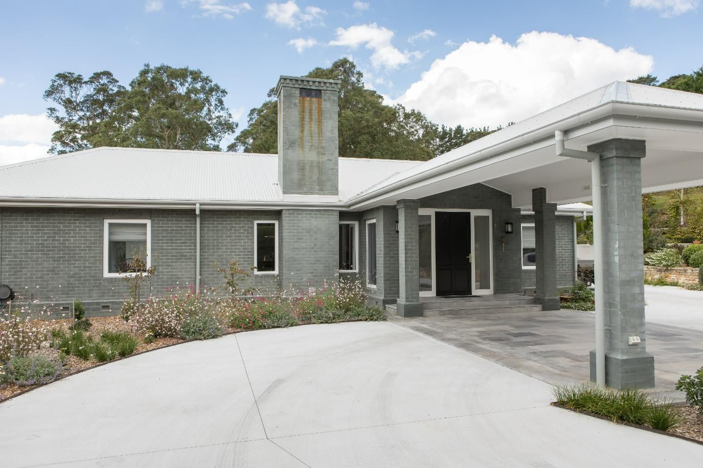 A Large House with A Concrete Driveway Leading to It — GMT Builders Pty Ltd in Kangaloon, NSW