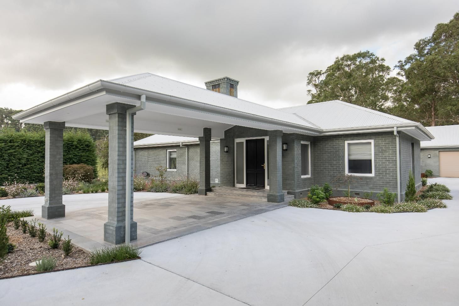 A Gray House with A White Roof and A Carport in Front of It — GMT Builders Pty Ltd in Berrima, NSW