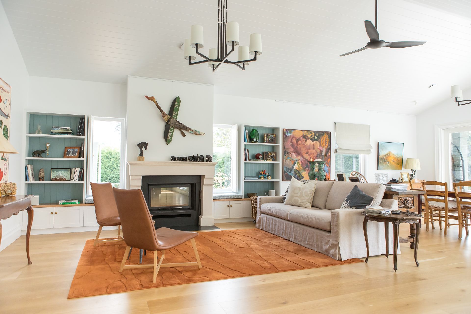 a Living Room With A Light Cream Lounge, Two Brown Chairs And A Fireplace — GMT Builders Pty Ltd in Nowra, NSW