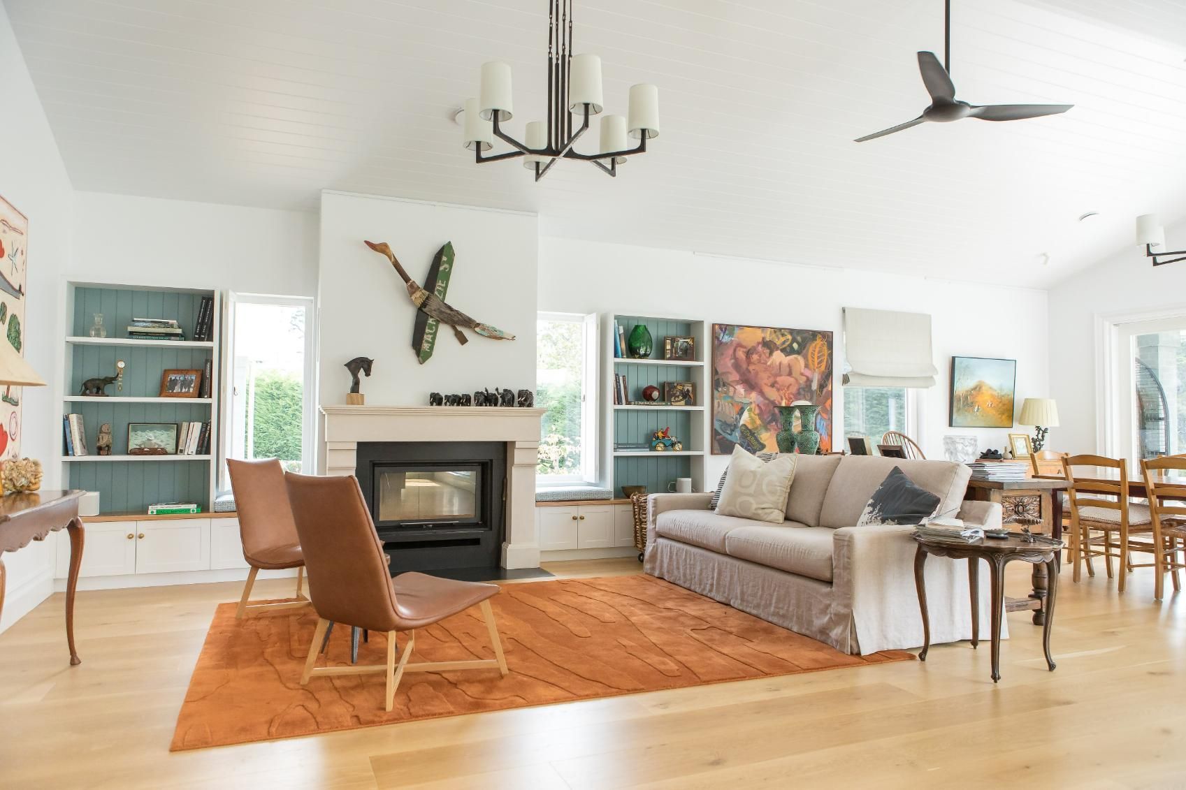 A Living Room with A Couch , Chairs , a Fireplace and A Ceiling Fan — GMT Builders Pty Ltd in Berrima, NSW