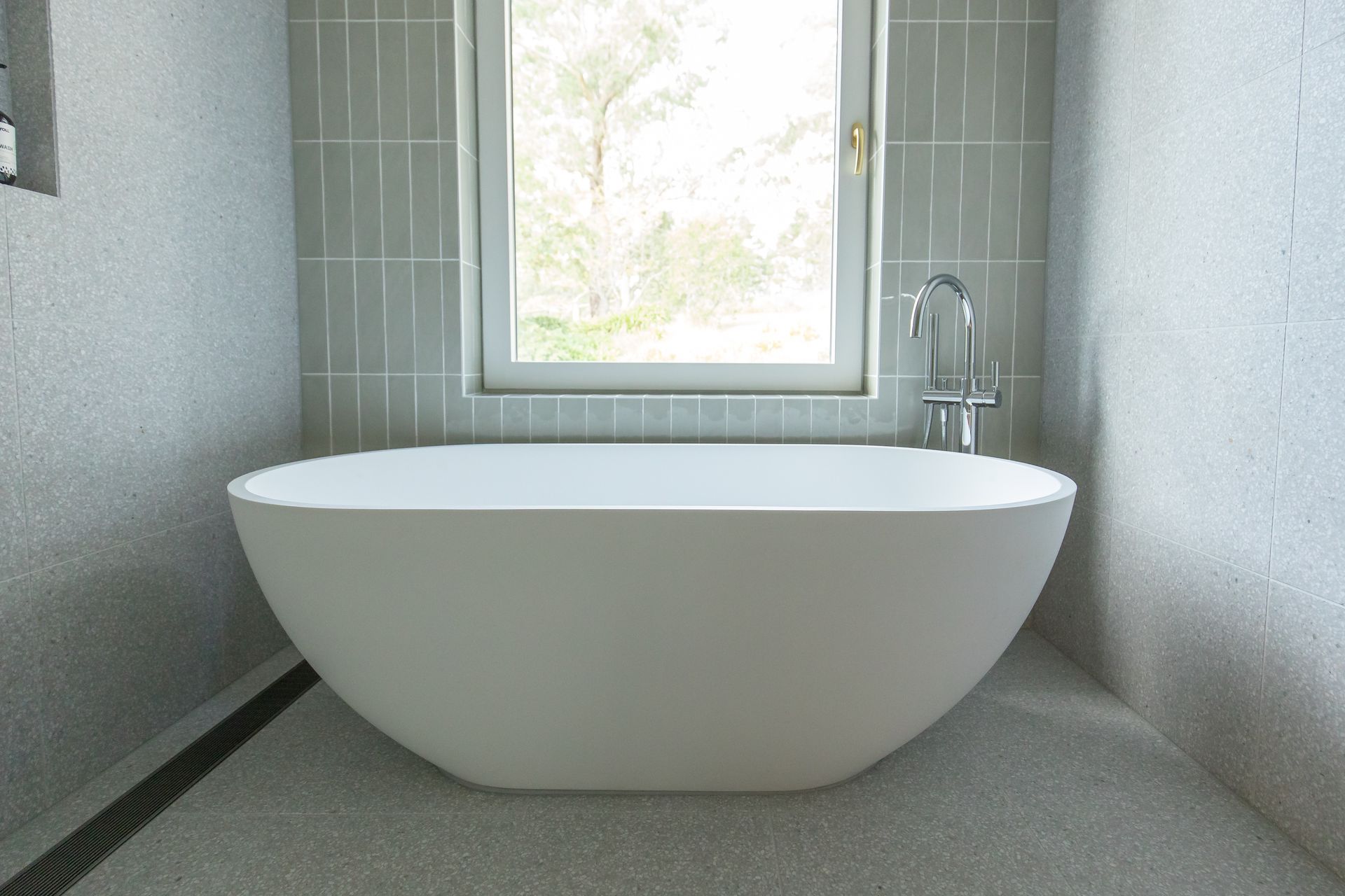 An Oval White Bathtub Below A Long Window — GMT Builders Pty Ltd in Nowra, NSW