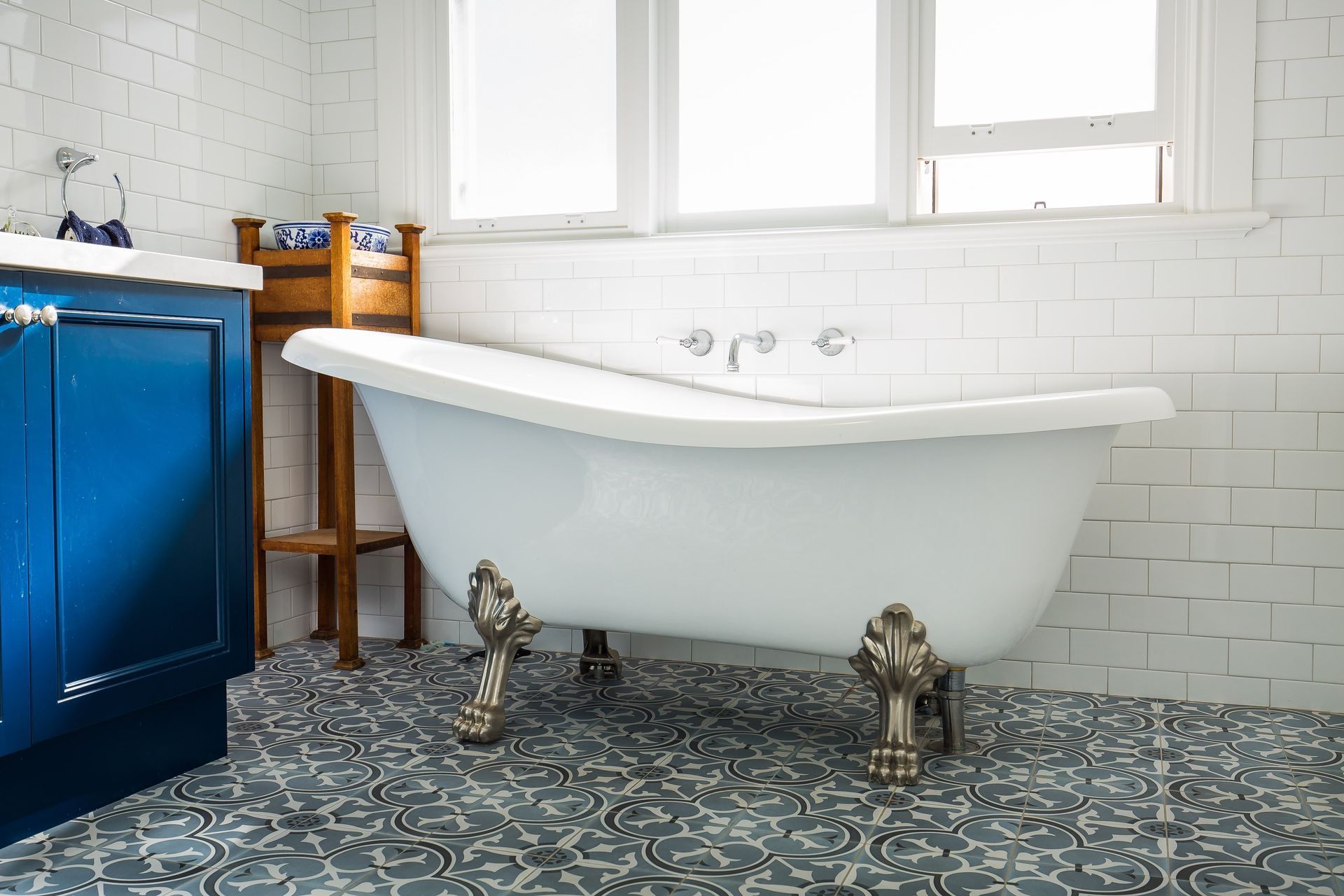A bathroom with a claw foot tub and blue cabinets — GMT Builders Pty Ltd in Bowral, NSW
