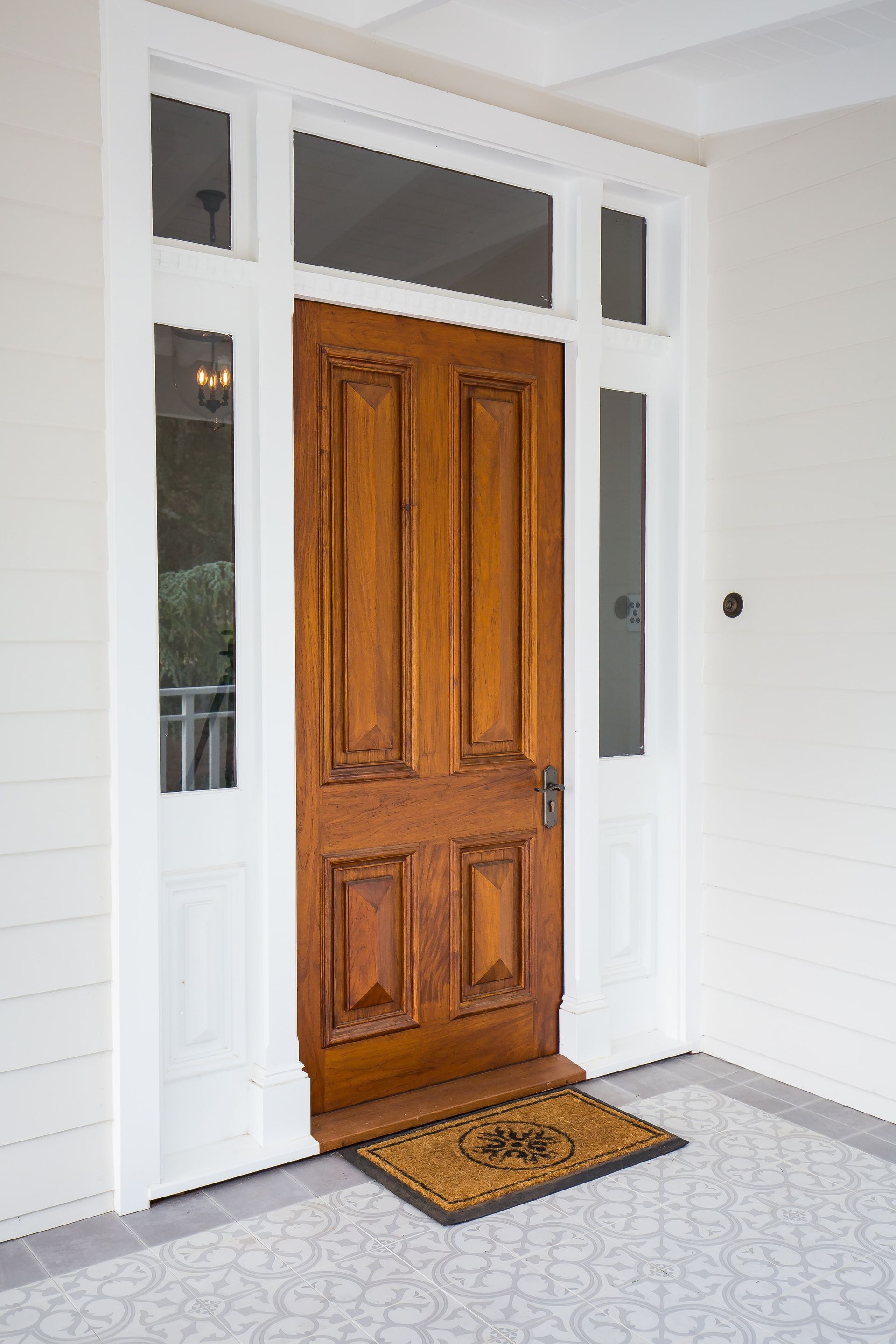 A wooden door with a door mat in front of it  — GMT Builders Pty Ltd in Bowral, NSW