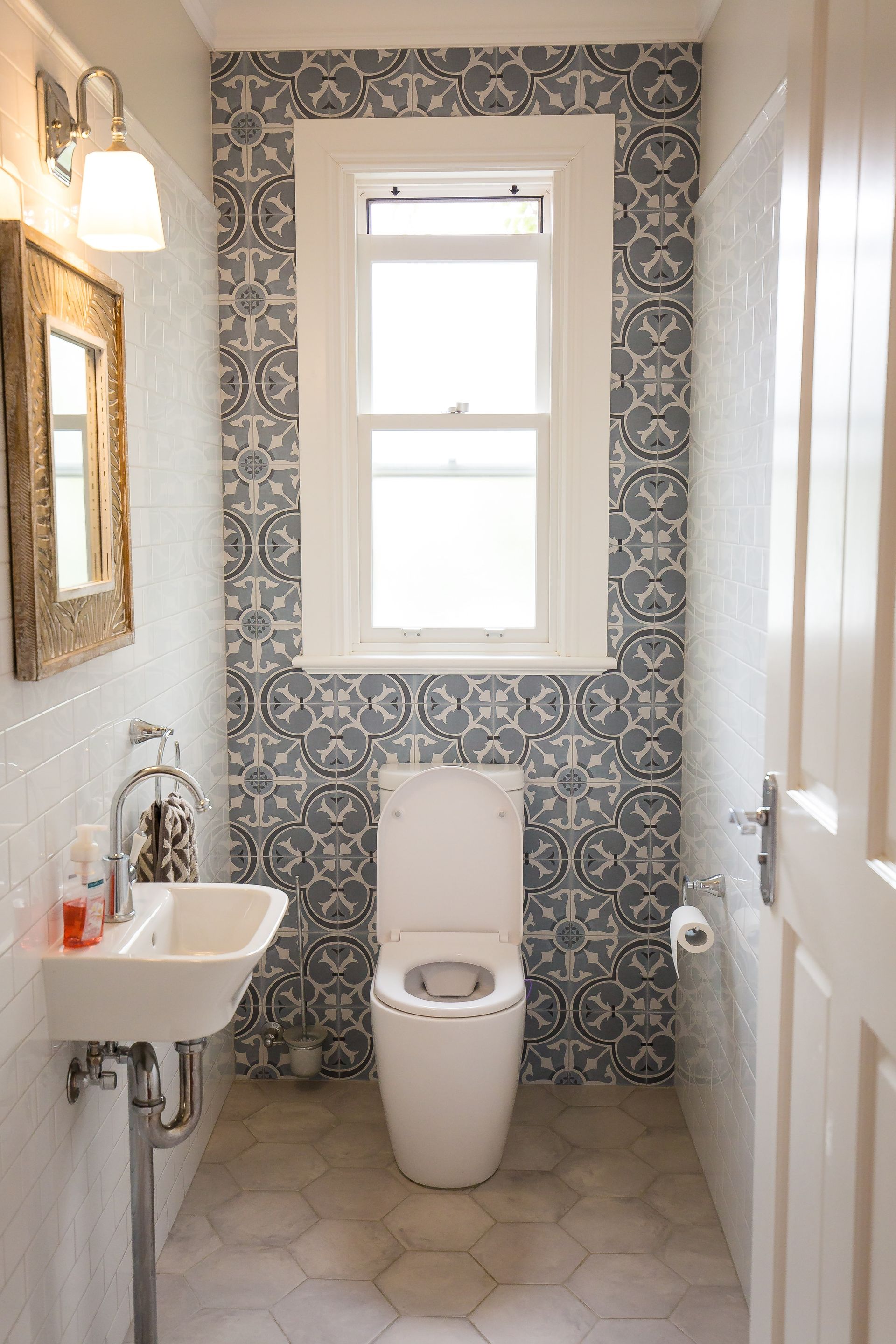 A bathroom with a toilet, sink, mirror and window — GMT Builders Pty Ltd in Bowral, NSW