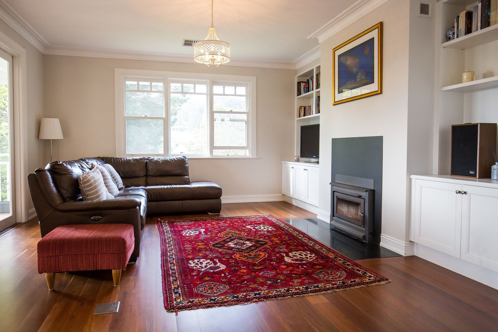 A living room with a couch, rug, fireplace and television — GMT Builders Pty Ltd in Bowral, NSW