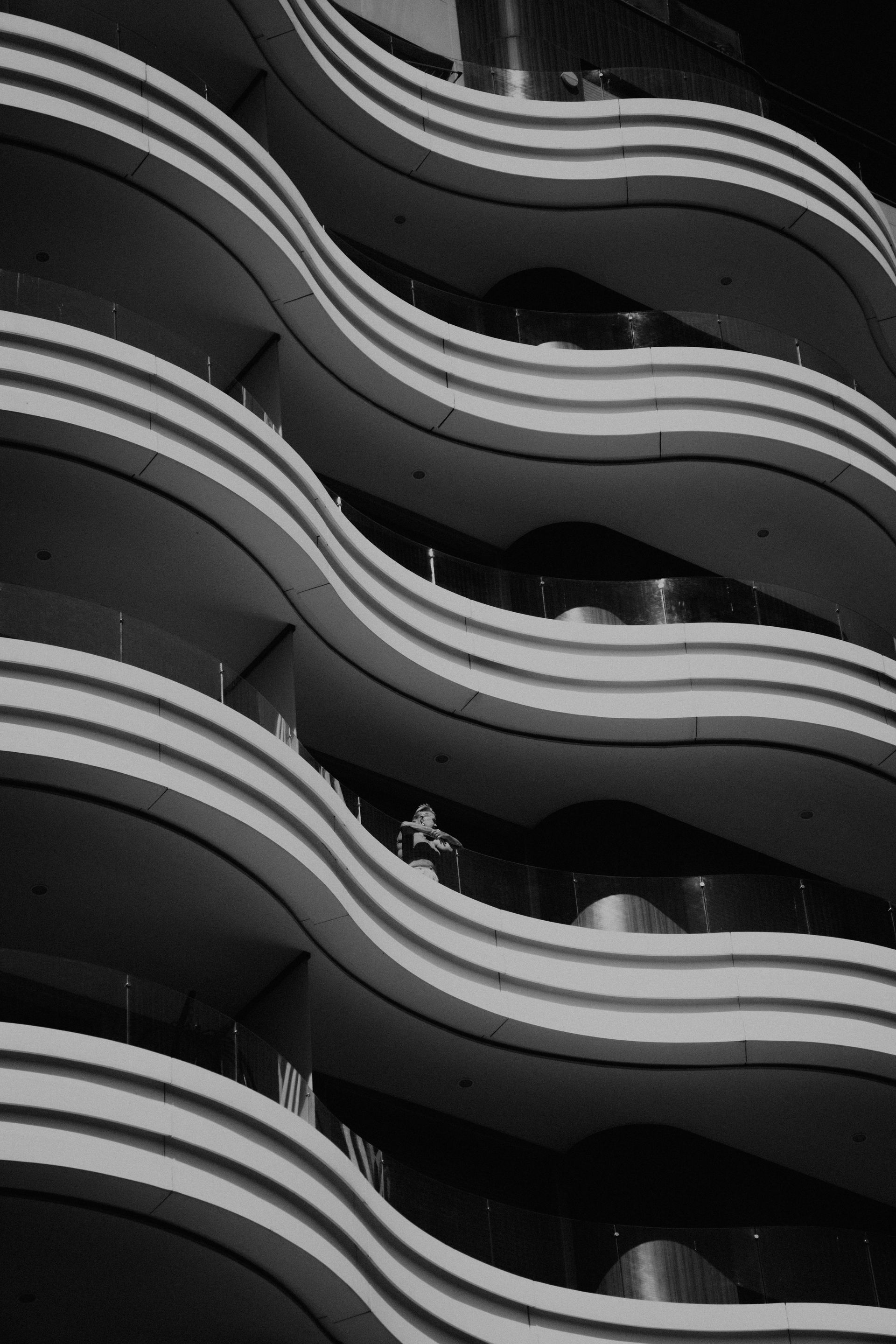 Black and white photo of a modern building facade with wavy balconies.