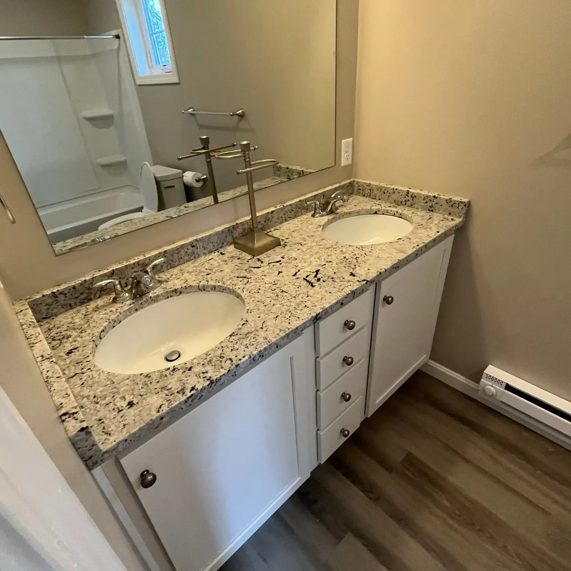 Pinette Plumbing - A bathroom with two sinks and a large mirror.