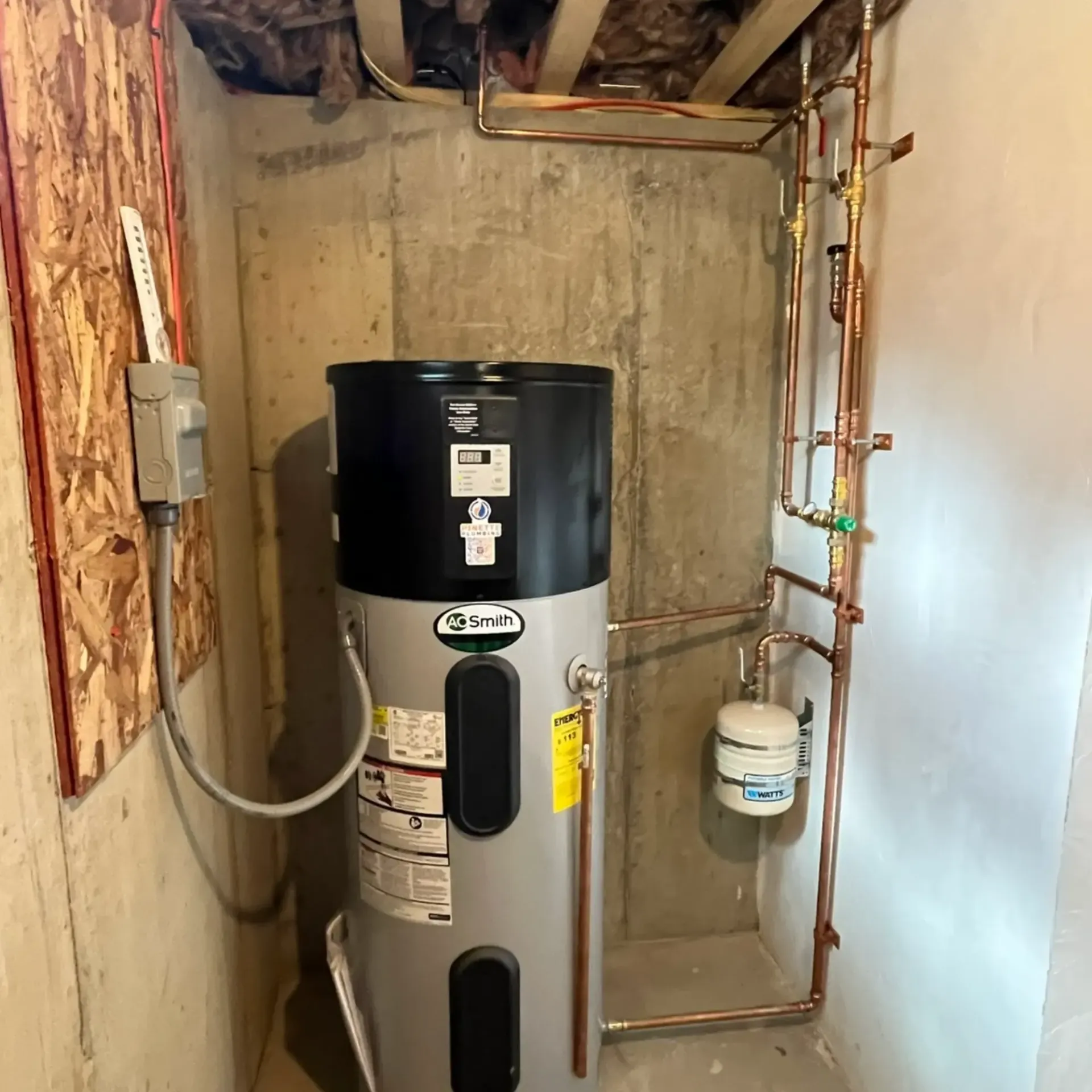 Pinette Plumbing - A water heater in a room with copper pipes