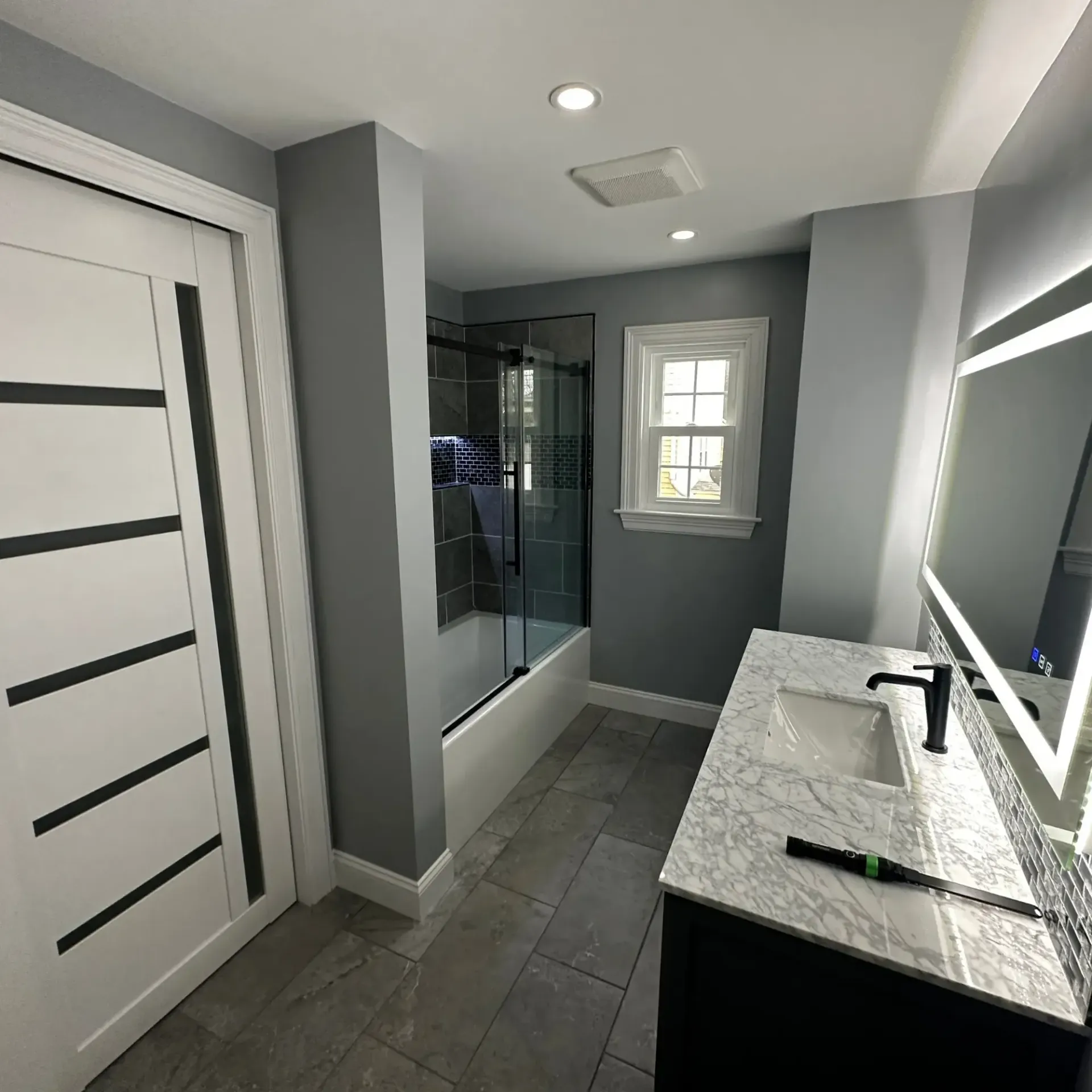 Pinette Plumbing - A bathroom with a sink , mirror and shower.