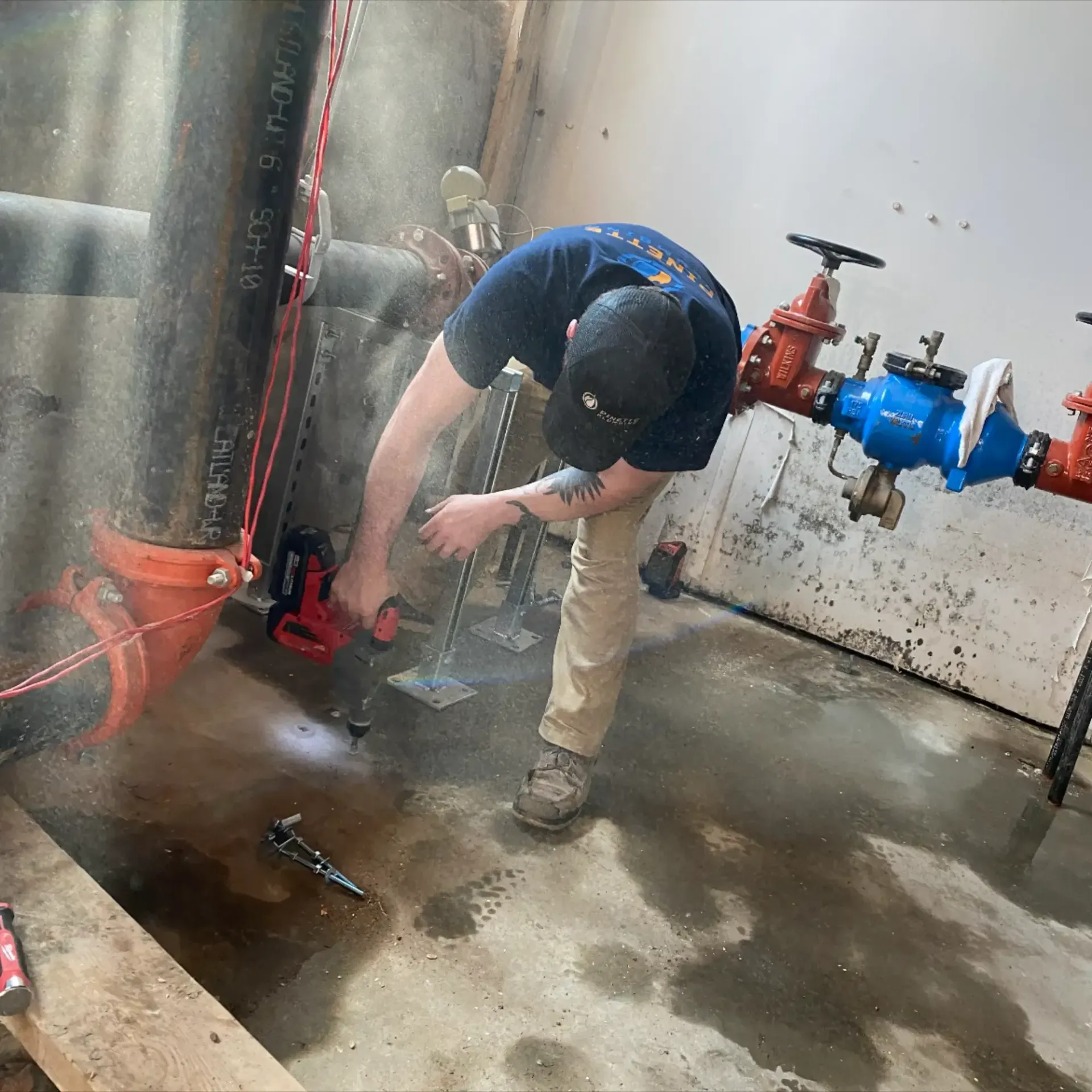 Pinette Plumbing - A man is working on a pipe in a room.
