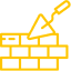 A trowel is laying bricks on top of a brick wall.