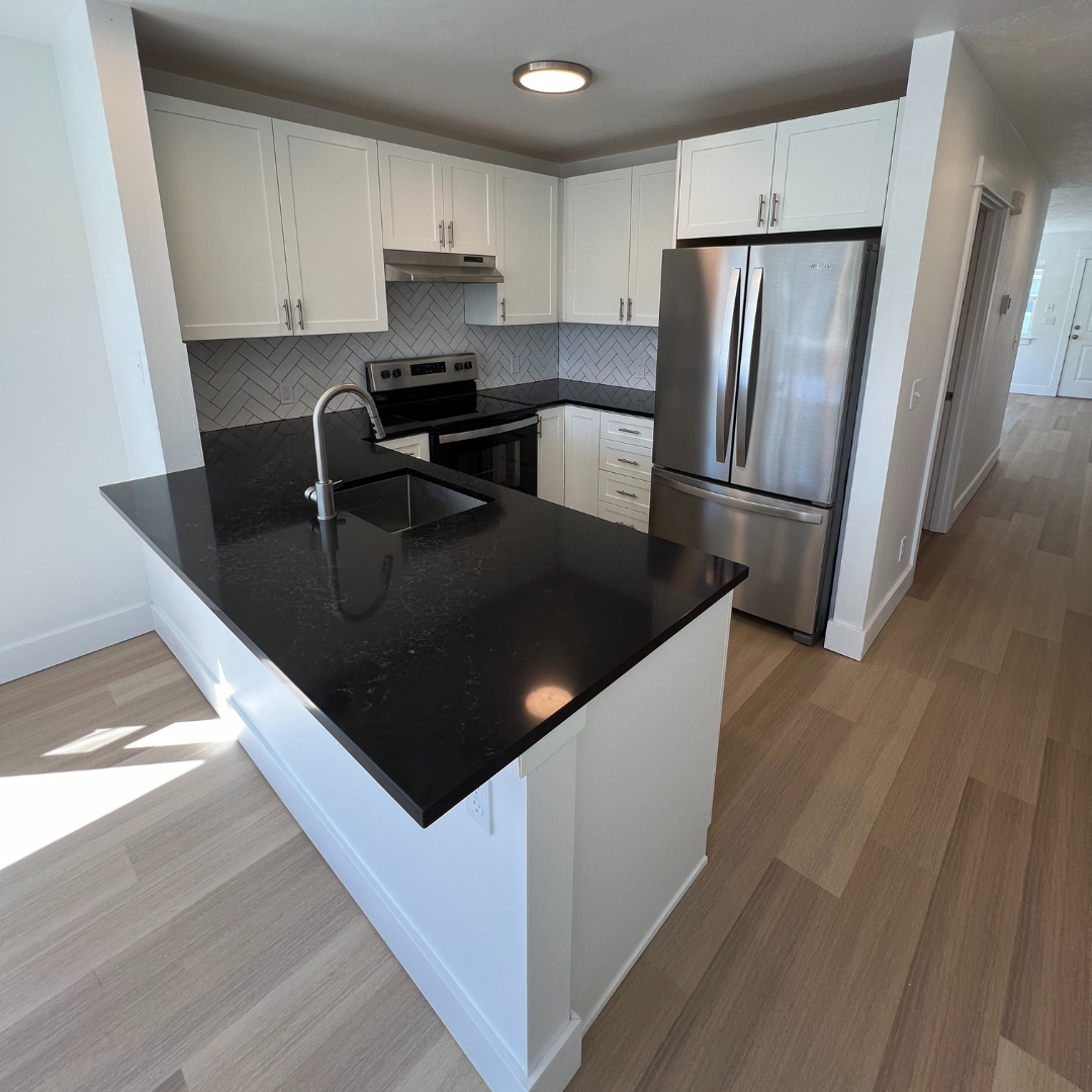 A kitchen with stainless steel appliances and black counter tops