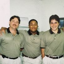 Three men are posing for a picture together in a room.