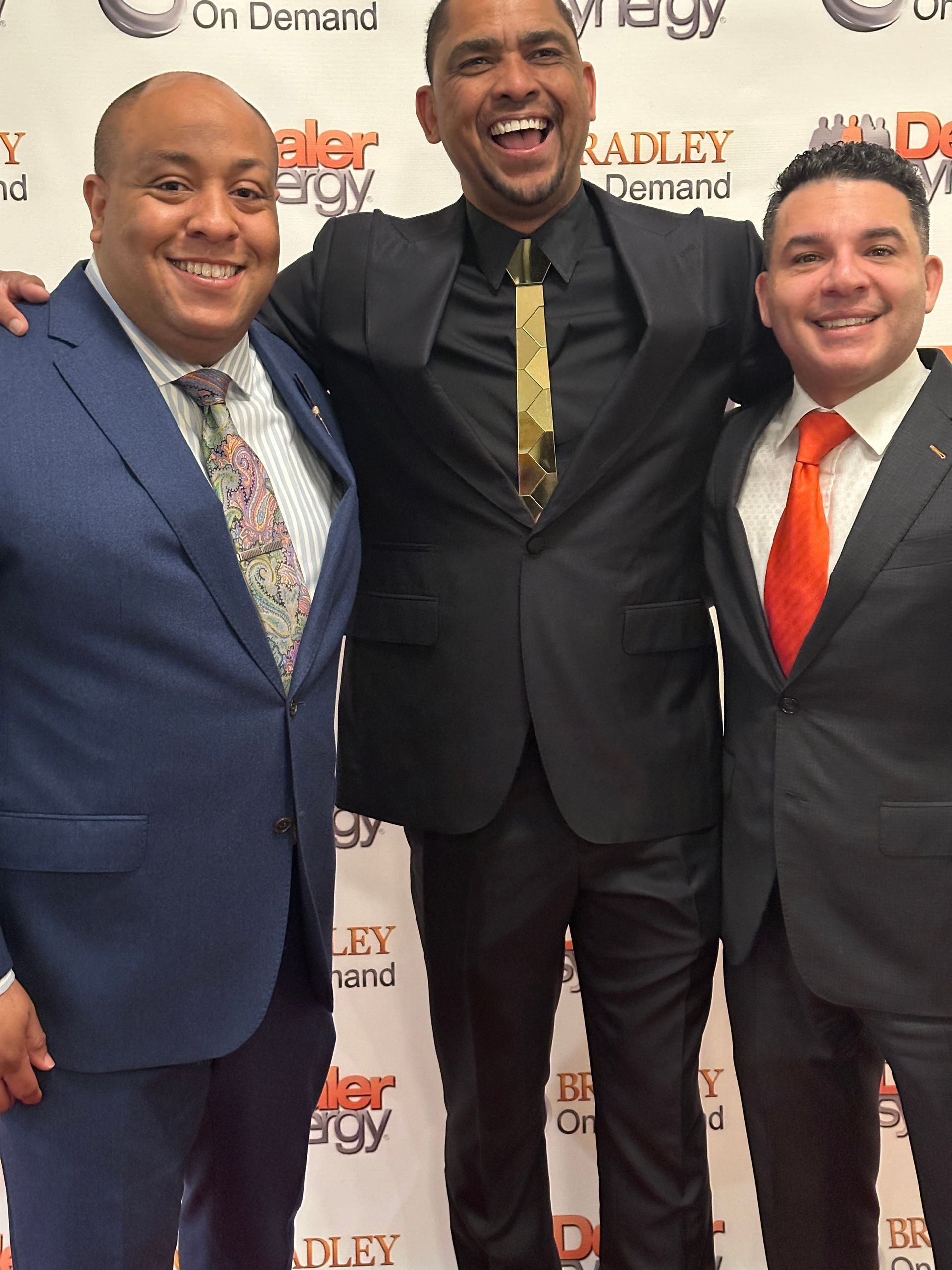 Three men in suits and ties are posing for a picture