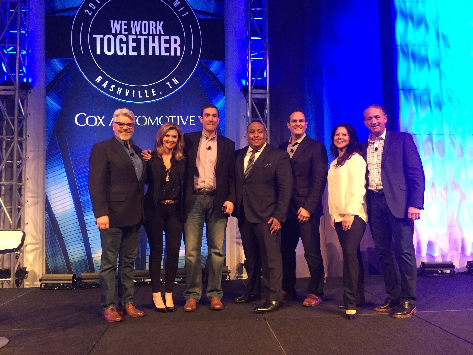 A group of people standing in front of a sign that says we work together