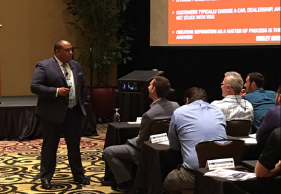 A man in a suit is giving a presentation to a group of people