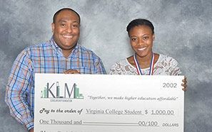 A man and a woman are holding a large check.