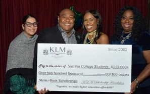 A group of people are standing next to each other holding a large check.