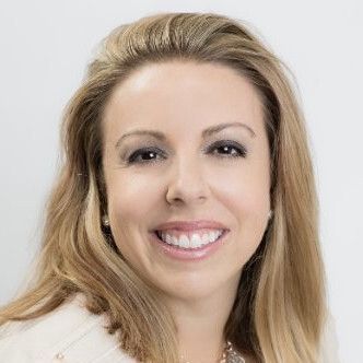 A woman with long blonde hair is smiling for the camera.