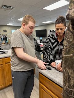 A man and a woman are standing at a counter in a kitchen.