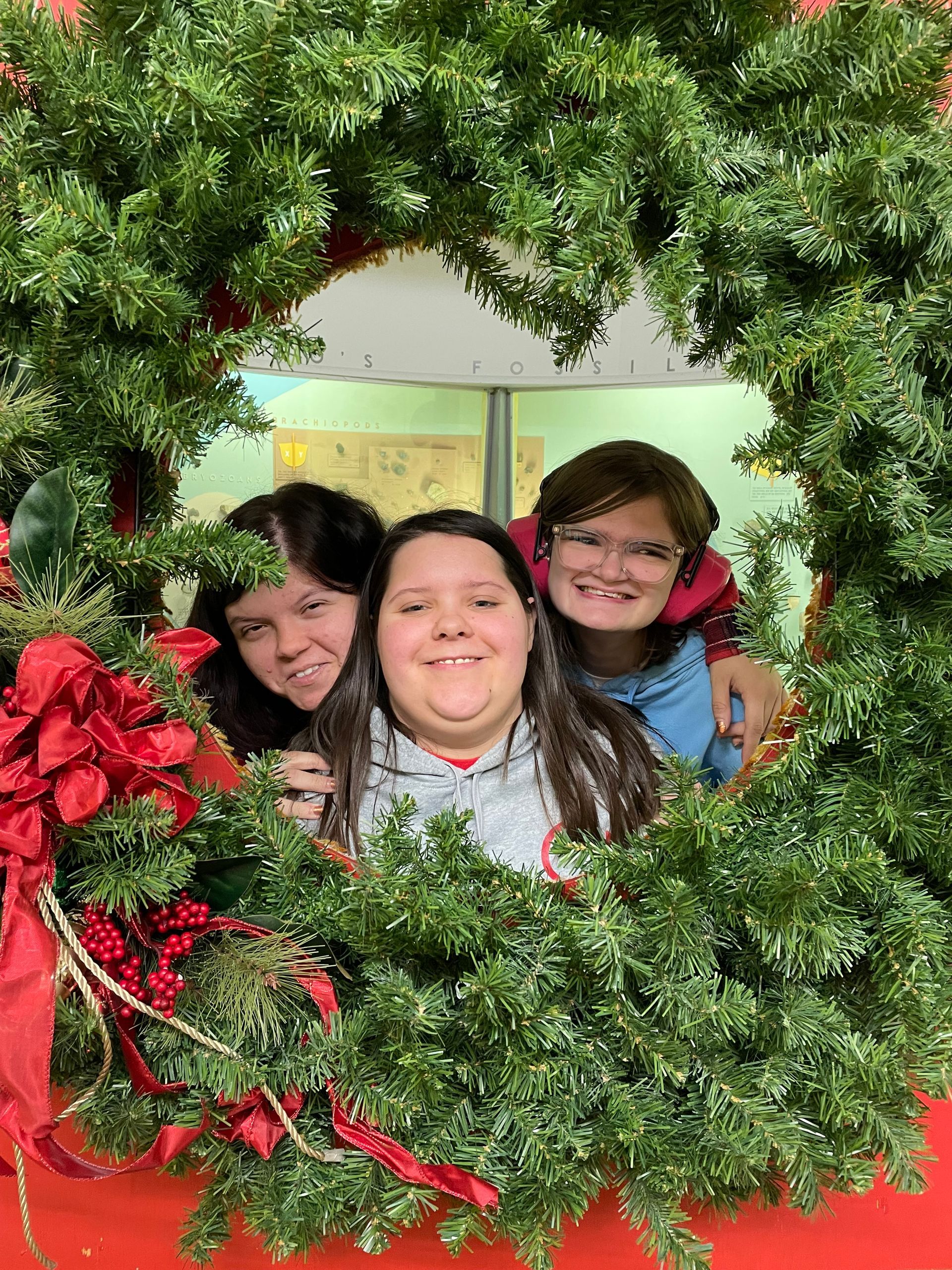 Two men are sitting at a table working on papers . one of the men is wearing a pink shirt.