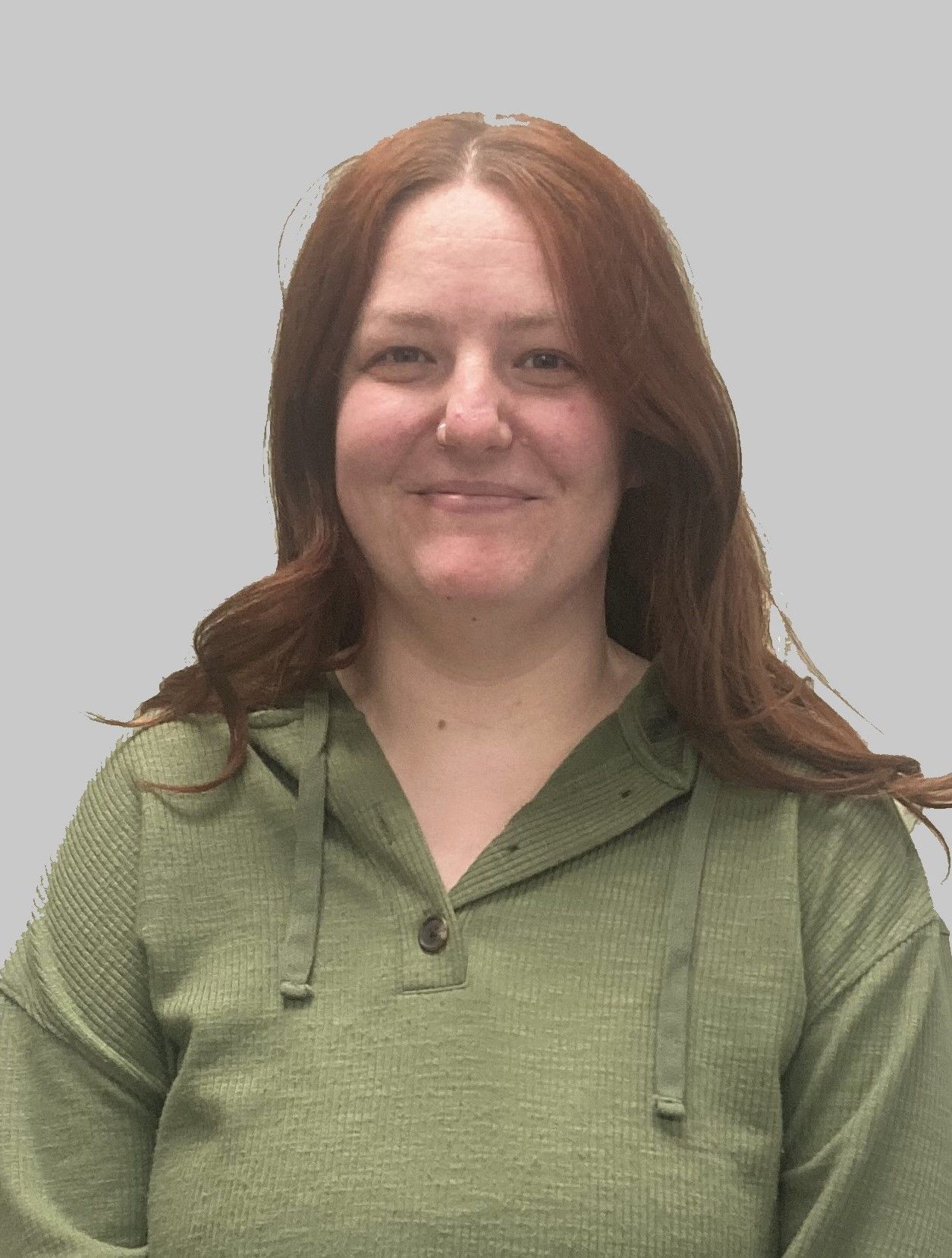 A woman with red hair is wearing a green sweater and smiling.