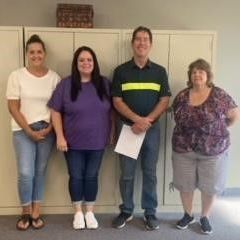 A group of people are standing next to each other in a room.