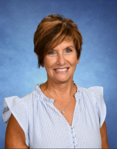 A woman in a blue and white striped shirt is smiling for the camera.