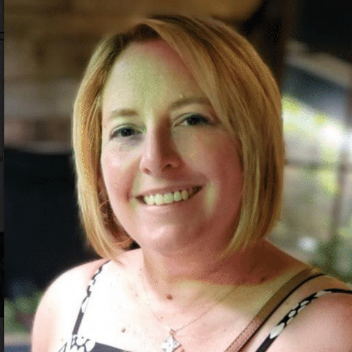 A woman with blonde hair is smiling for the camera