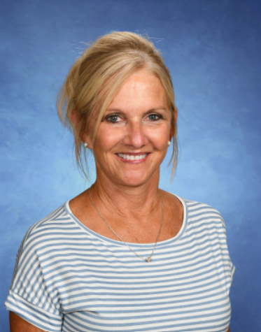 A woman in a striped shirt is smiling for the camera.