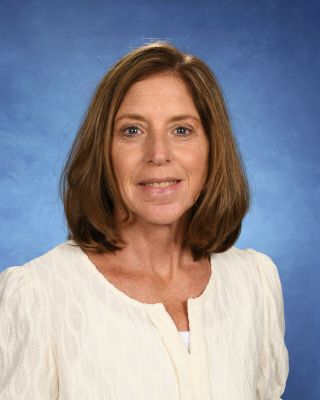 A woman in a brown shirt is smiling for the camera.