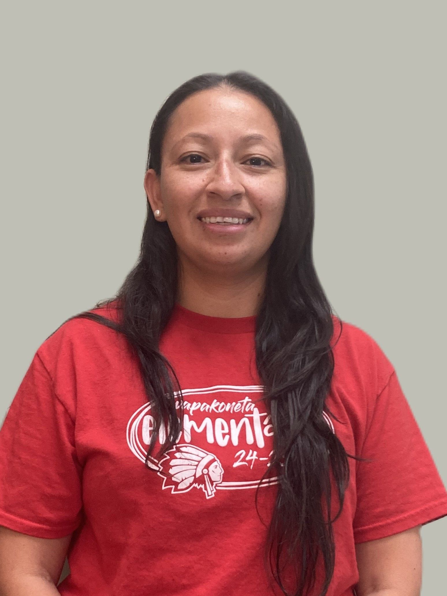 A woman wearing a red shirt is smiling for the camera.