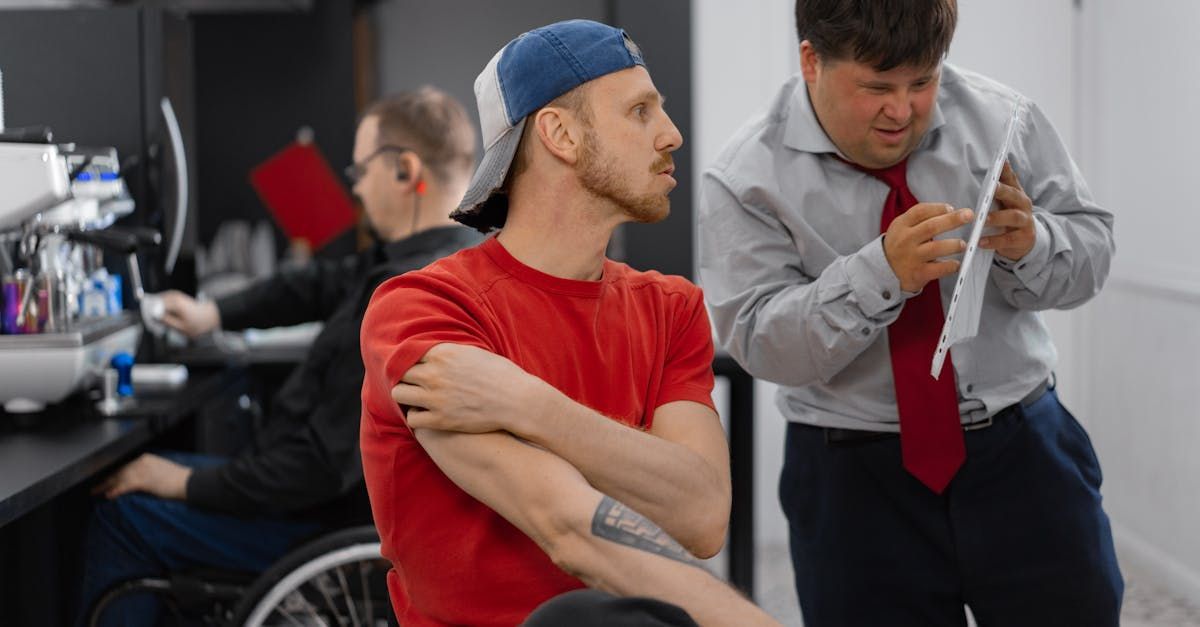 A man in a wheelchair is talking to a man in a tie.