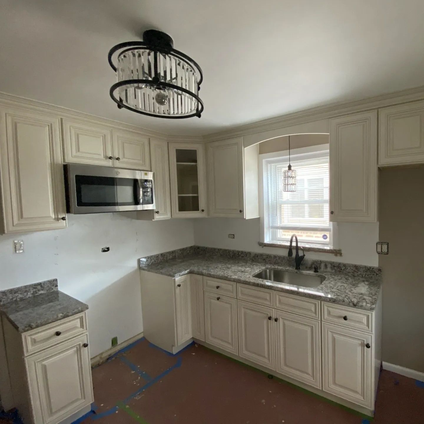 A kitchen with white cabinets and granite counter tops