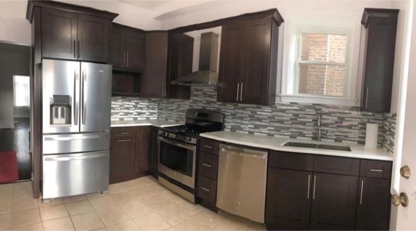 A kitchen with stainless steel appliances and wooden cabinets.