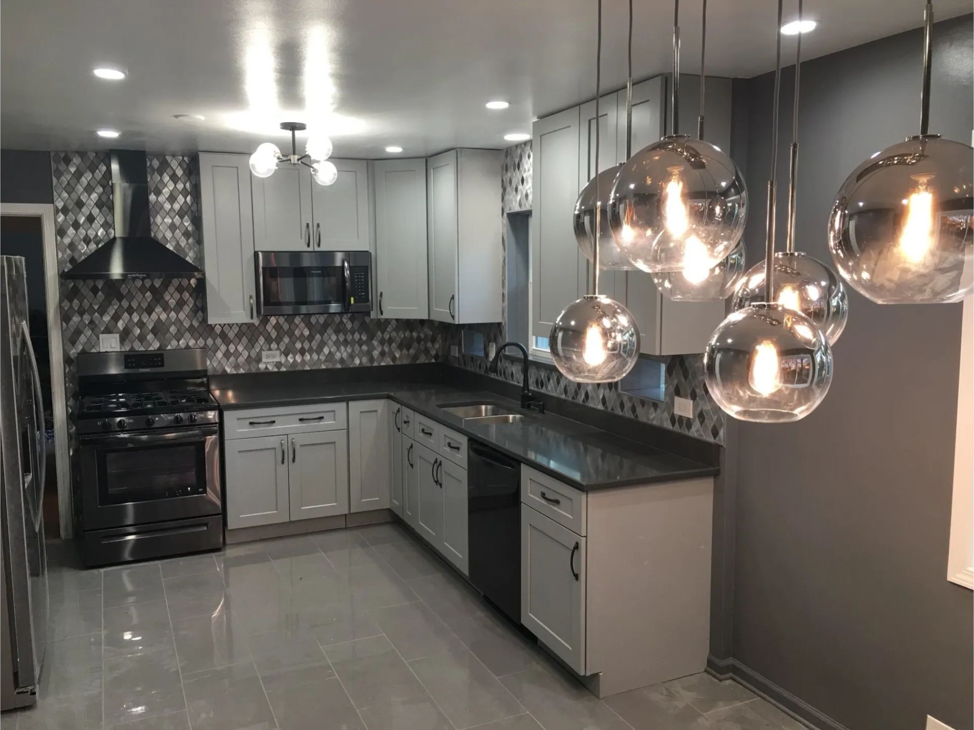 A kitchen with white cabinets, stainless steel appliances, granite counter tops, and a stove.