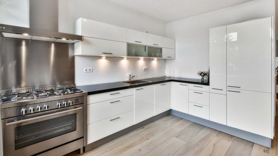 A kitchen with white cabinets and a stove top oven