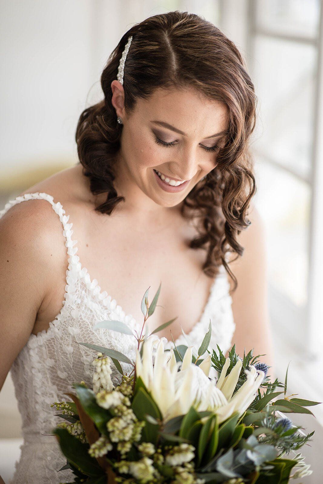 A bride in a wedding dress is holding a bouquet of flowers.