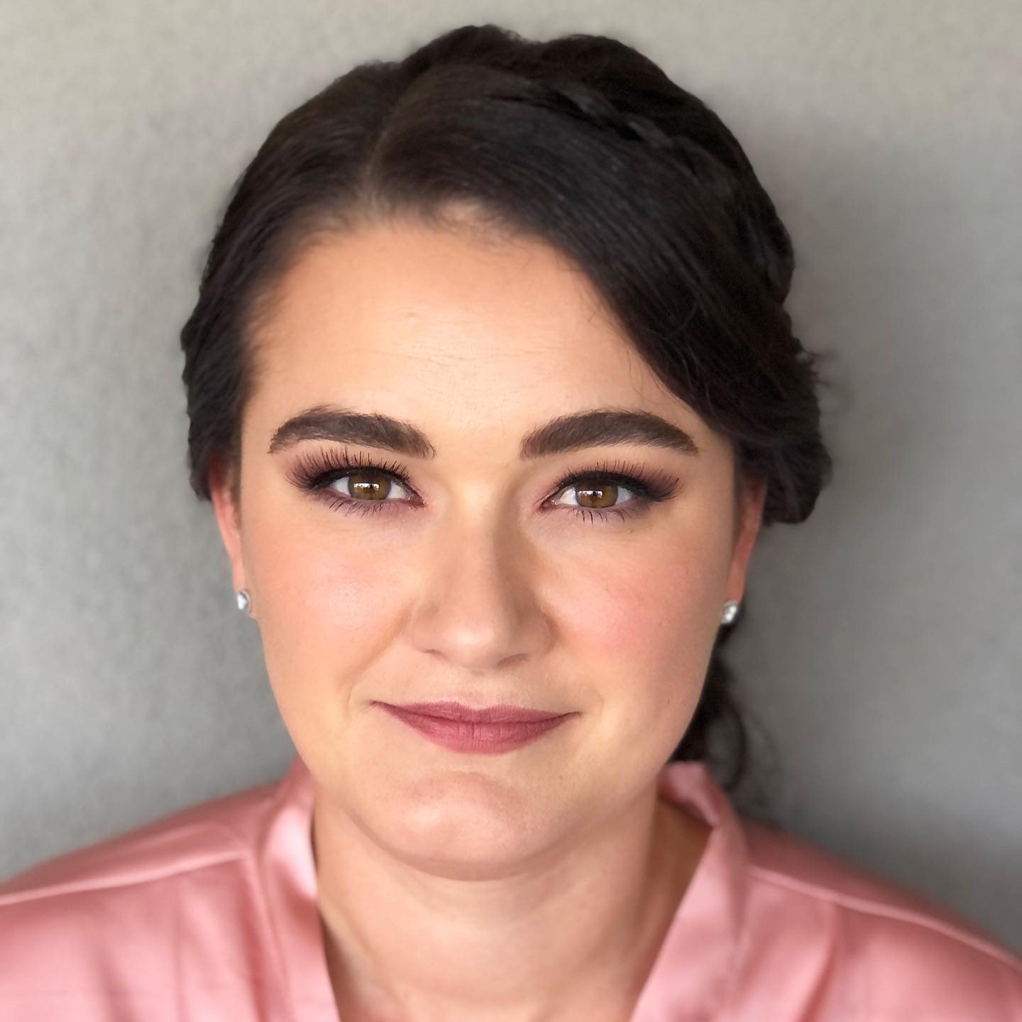 A woman in a pink robe is smiling for the camera.
