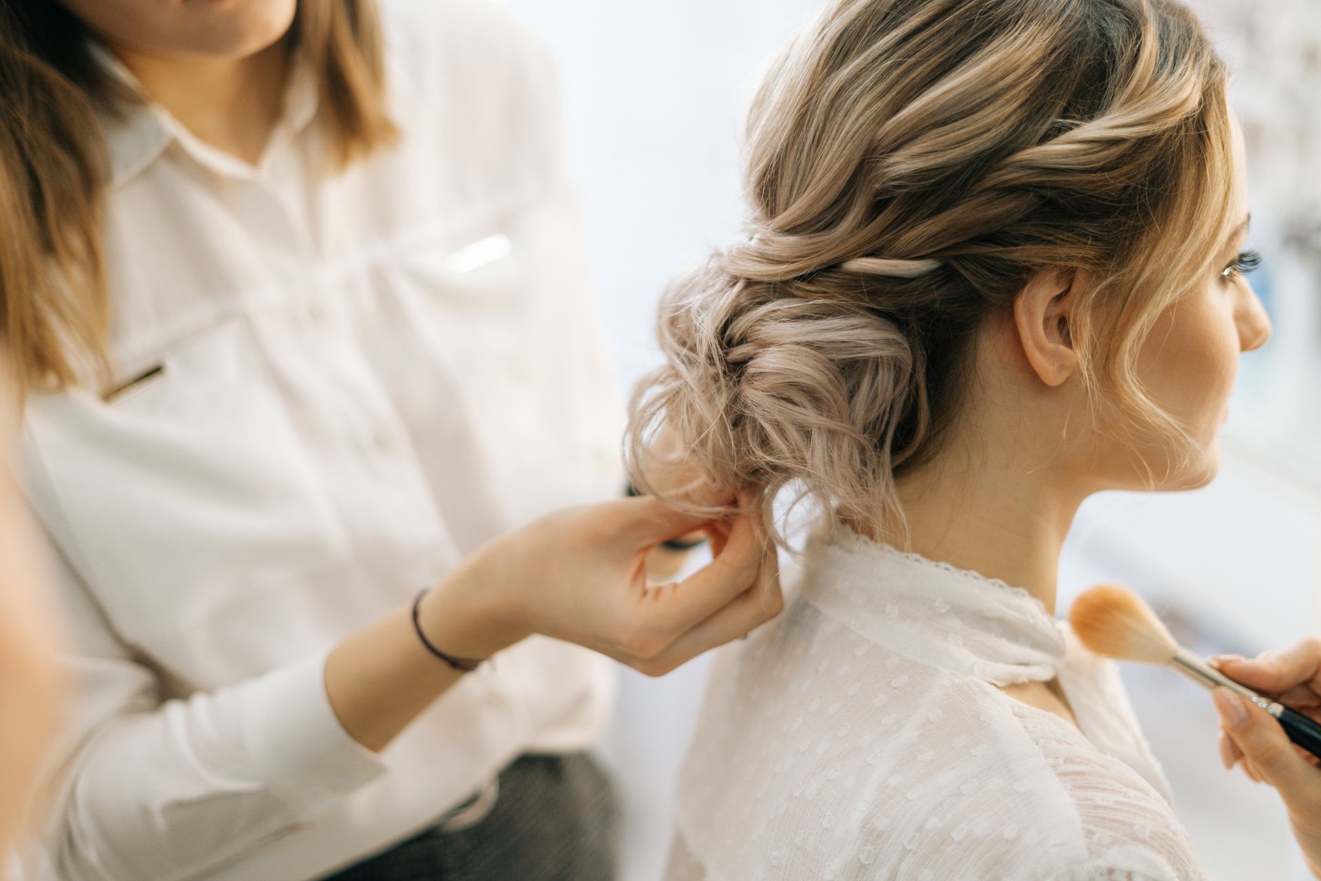 A woman is getting her hair done by a hairdresser.