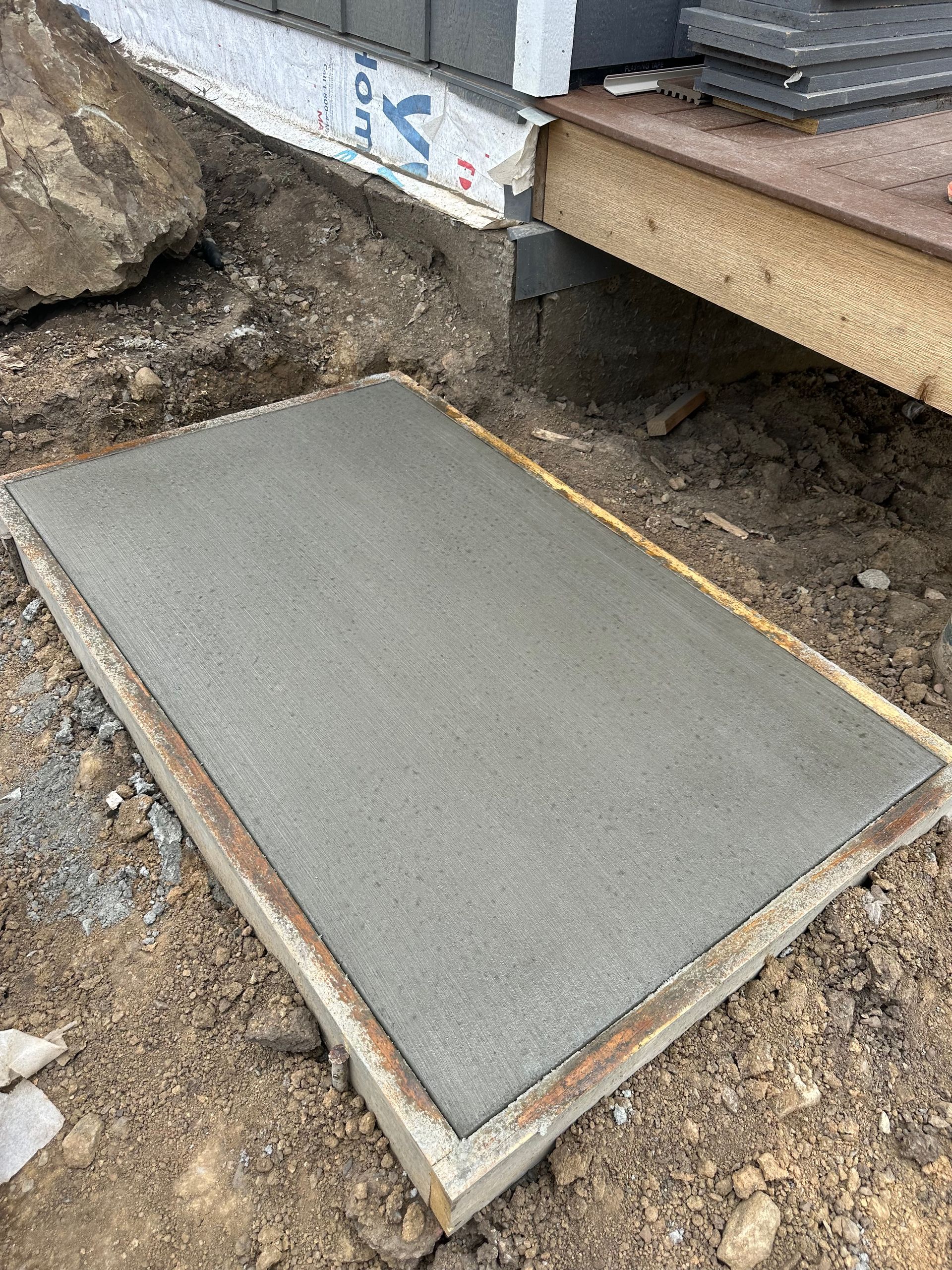 Freshly poured concrete slab in a wooden frame on a construction site.