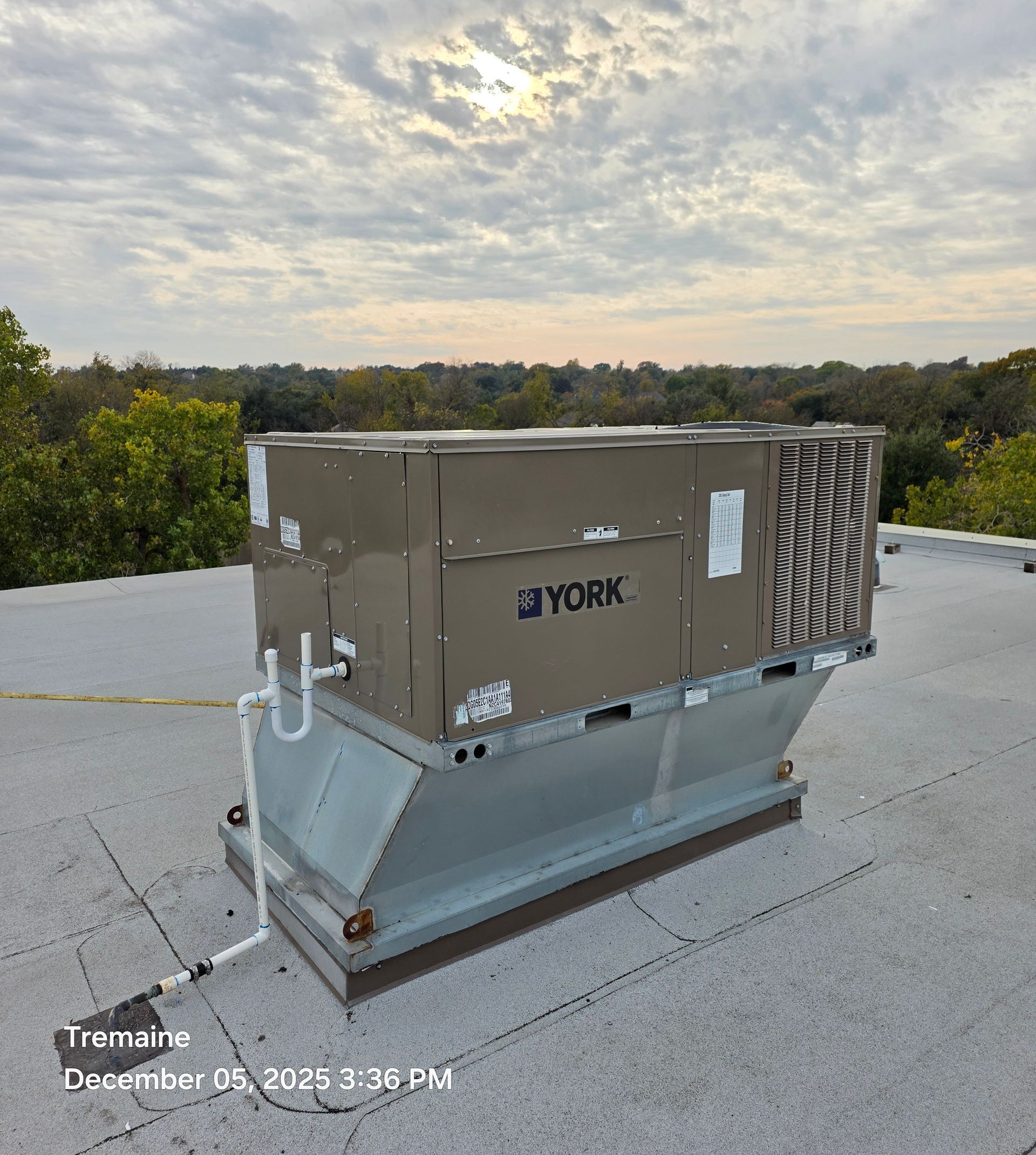 York HVAC unit on a rooftop, with a cloudy sky backdrop.