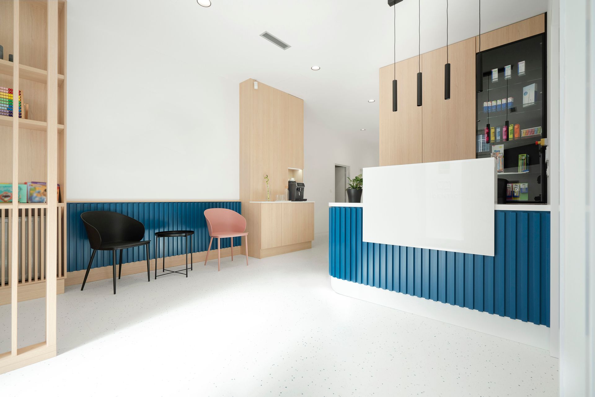 A waiting room with a blue counter and chairs.